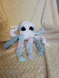 Casper the Ghost Octopus sitting upright with eight legs.