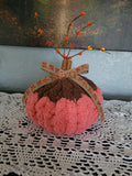 Handmade orange and brown chenille pumpkin with cinnamon‑stick stem and fall ribbon.