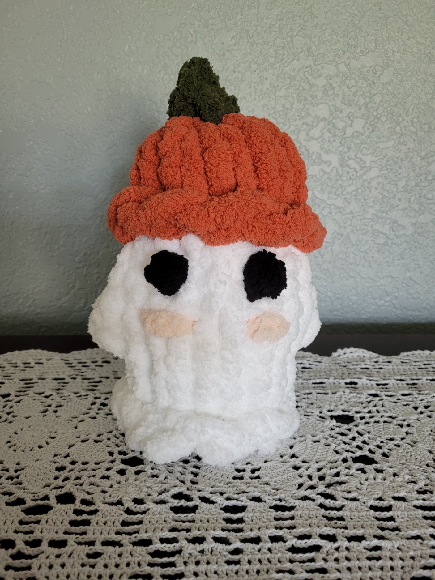 Front view of handmade white ghost plush with pumpkin hat