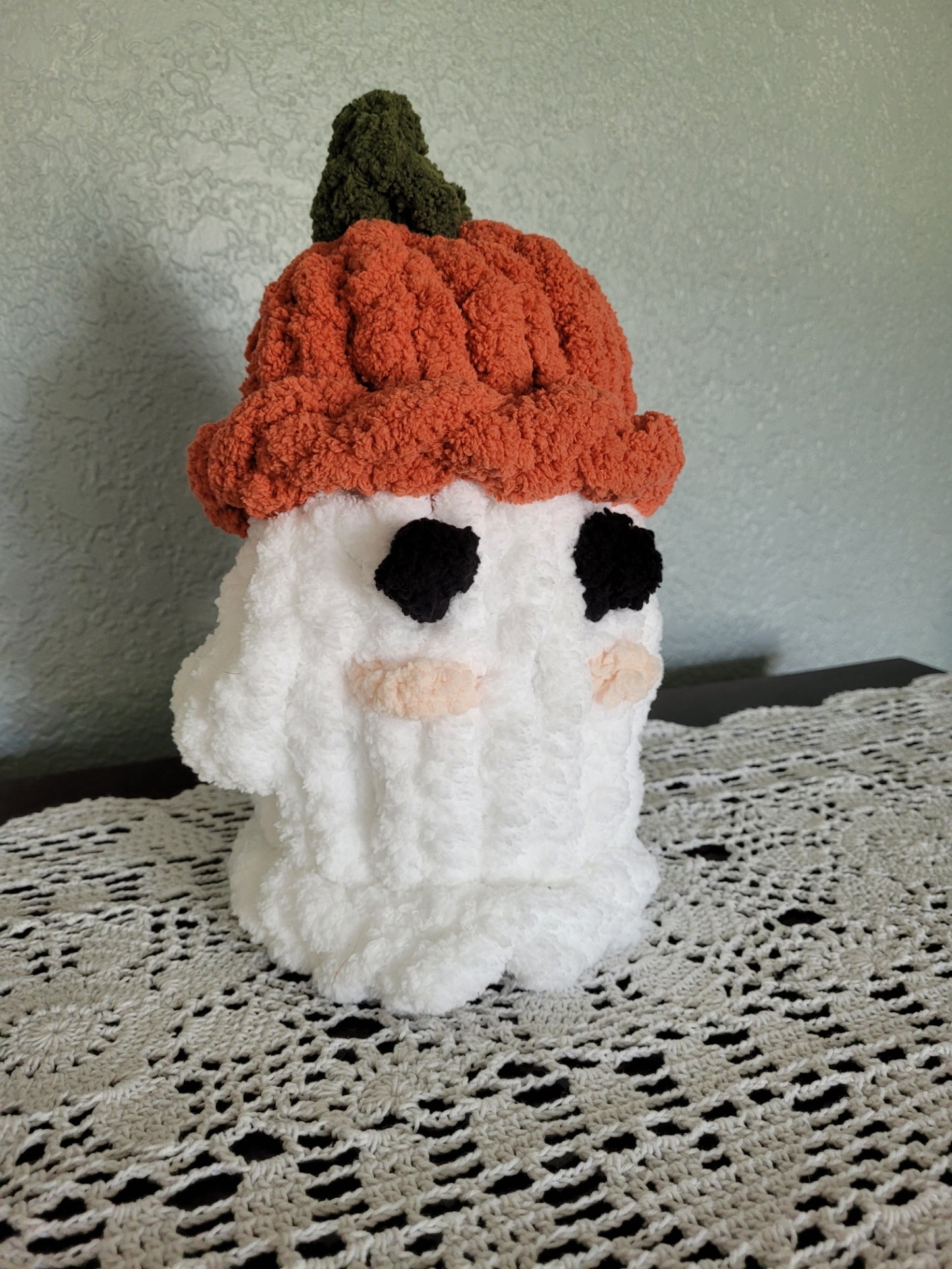 Angled view of handmade pumpkin‑hat ghost plush showing chenille texture and hat details.