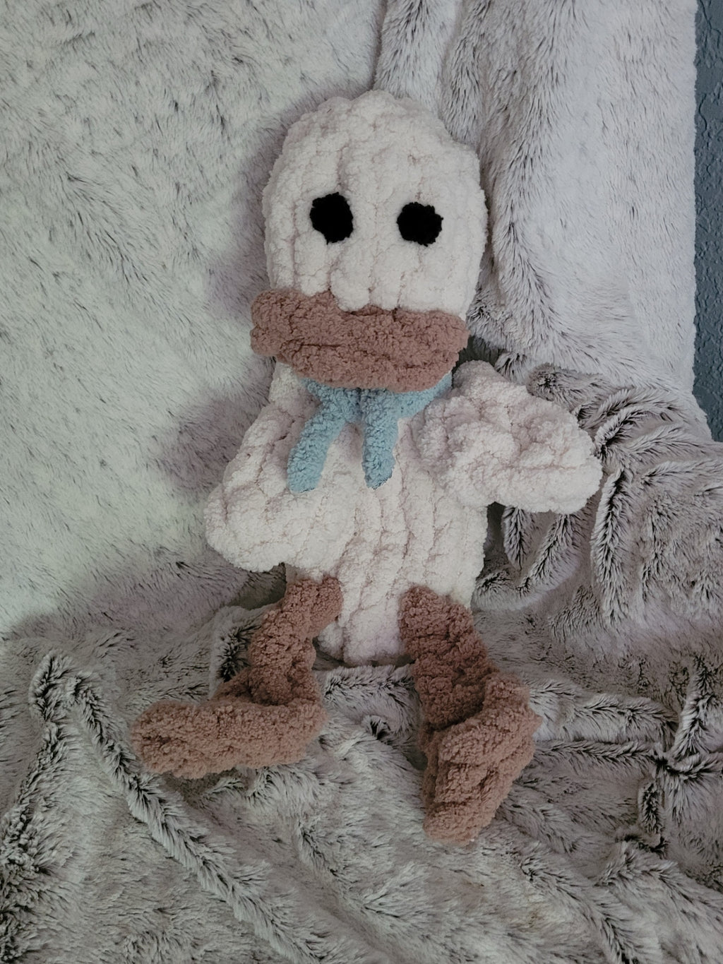 Handmade beige duck plushie named Webby with dangling feet and teal scar